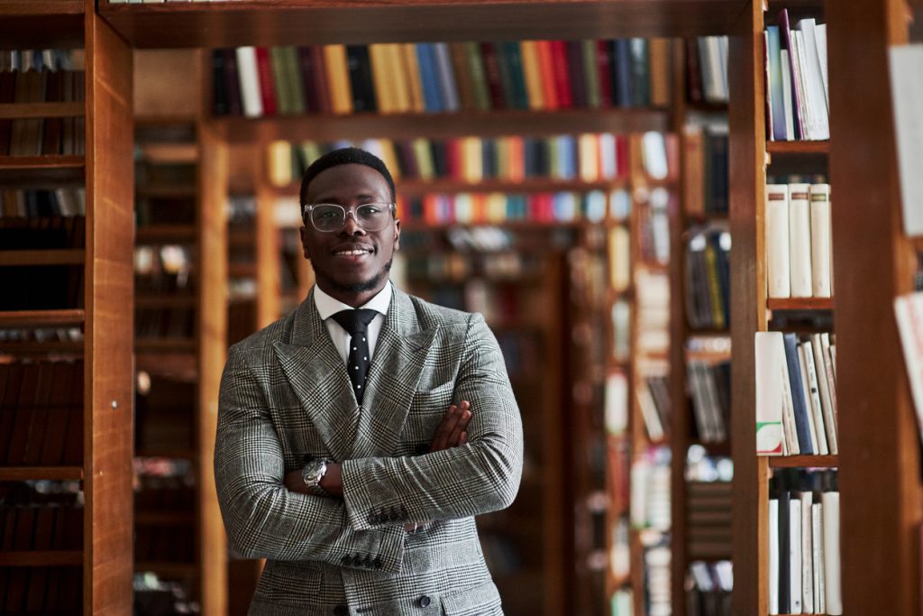 Man standing in library corridor 